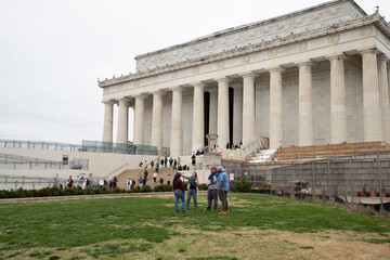 A group standing in front of the Lincoln Memorial under construction