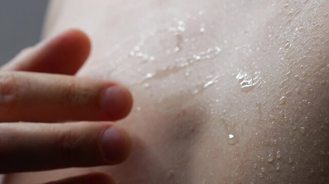A man's wet and naked body.
Drops of water on his bare torso after a shower.
A sweaty guy touches his skin.
Naked and sweaty skin from the heat.
Body, naked, hygiene, sweaty