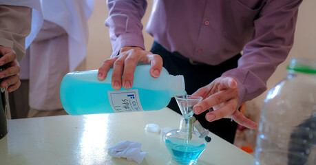 Scientists Pouring Laboratory Solution in Science Laboratory