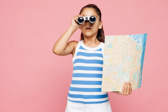 Traveler shocked kid child wear casual clothes read map use binocular isolated on plain pink background. Tourist travel abroad in free time rest getaway Air flight trip journey vacation relax concept.