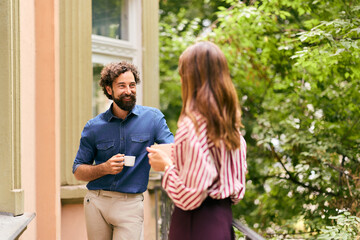 Fototapeta premium Man and Woman Enjoying Coffee Conversation on Terrace Outdoors