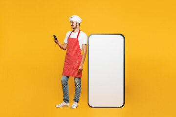 Full body young happy housewife housekeeper chef cook baker man wear red apron toque hat big huge...