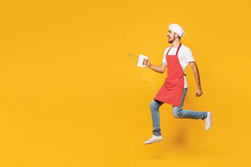 Full body profile young housewife housekeeper chef cook baker man wear red apron toque hat jump...