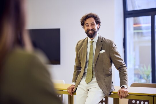 Confident Professional Man Smiling in Modern Office Environment During Daytime