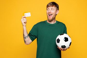 Young shocked man fan wears basic green t-shirt cheer up support football sport team hold in hand...