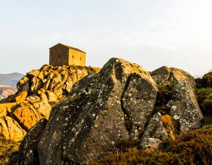 Small chapel atop rocky outcrop at golden hour