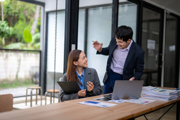 Business people discussing work in office meeting using laptop and documents