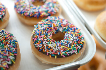 Donuts, sweet snack with various topping which are prepared for sale at the bakery shop. Sweet food object photo.