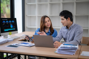 Asian business people working and discussing using laptop computer in office