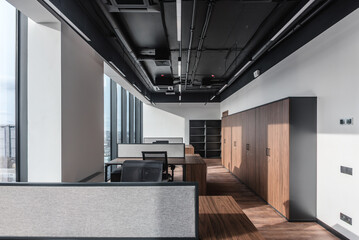 Part of ordinary office room decorated in modern style. Executive office with wooden desk and panoramic cityscape window