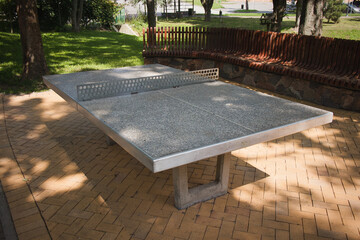 A ping pong table is sitting on a brick patio