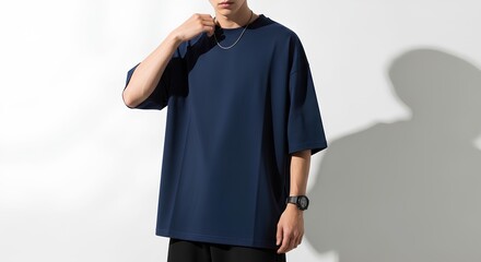 Minimalist street style fashion with a young man wearing a plain navy oversized tee and accessories. Casual urban clothing mockup