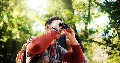 Explore, hike and couple in forest with binocular, bird watching or bonding in holiday hobby....