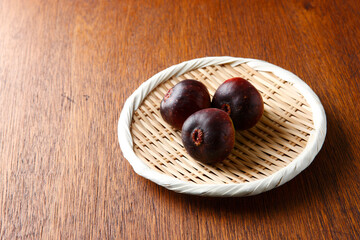 笊に盛ったイチジク3個　木目背景