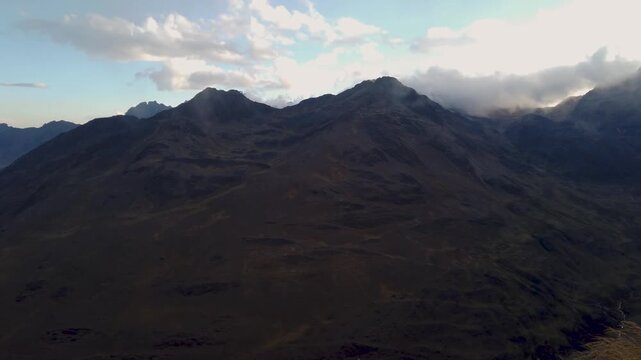 High mountain ridges and valley with a winding road appear under evening light near Cusco, Peru, Sacred Valley region, view from Amparaes high altitude point