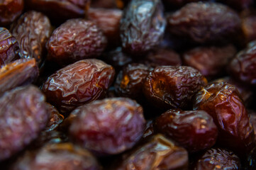Surface texture of selected dried dates. Natural oriental sweets. Close-up of dried dihydrated fruits