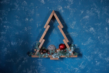 Christmas decoration in the form of a wooden Christmas tree on a blue background.