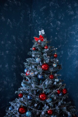 Christmas tree decorated with toys, red balls on a blue background.