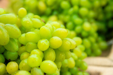 A bunch of white grapes lies on the counter in a vegetable store