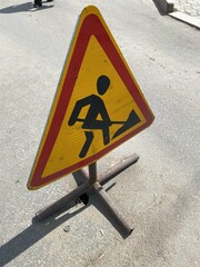 There is a road work ahead and a warning sign on the road