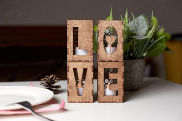 Wooden candlesticks in the form of the word Love.