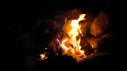 Campfire, tea on wood fire and warming campers at night camp