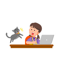 A little girl at her study desk surprised by her jumping cat