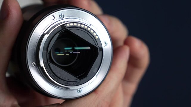 A bayonet mount on a camera lens.
A metal bayonet mount and lens attachment to a film or still camera.
A modern camera lens in the photographer's hands.
Photo, video, equipment, camera, bayonet mount