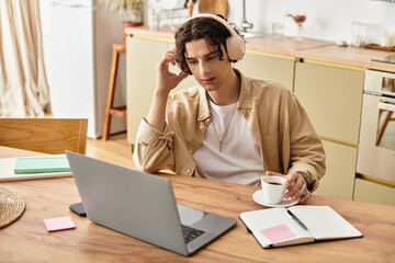 Handsome young professional engages in remote work while enjoying coffee in a modern workspace