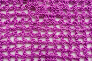 Purple crocheted fabric close up, handmade textile with openwork pattern