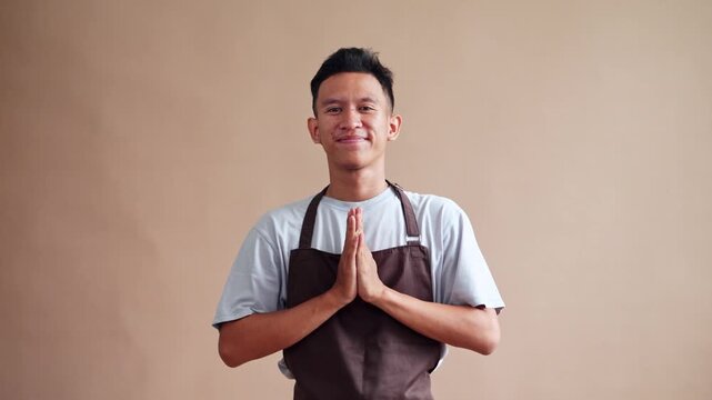 Friendly Barista in apron welcoming guests with grateful gesture perfect for hospitality needs