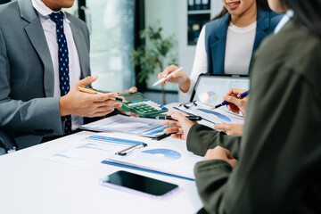 Businesswoman and team analyzing financial statement Finance task. with smart phone and laptop and  tablet. Wealth management concept