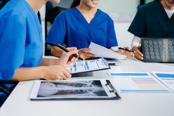 Doctors and consultant discussing brain scan and lab reports in a modern clinic. Healthtech, diagnostics, teamwork, and patient care concept