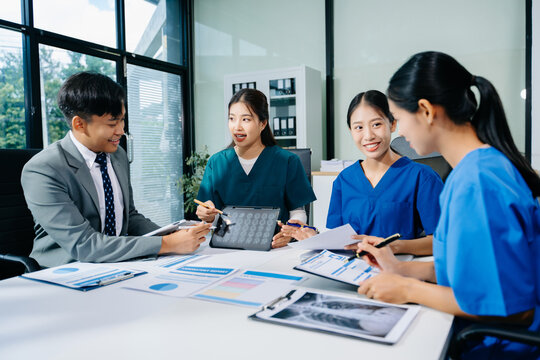 Doctors, nurses, and consultant review anatomy data on tablet and lab reports in a modern clinic. Healthtech, diagnostics, teamwork, and medical collaboration.