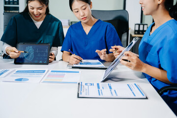 Doctors, nurses, and consultant review anatomy data on tablet and lab reports in a modern clinic....