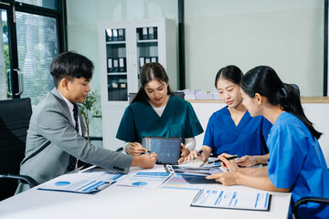 Doctors, nurses, and consultant review anatomy data on tablet and lab reports in a modern clinic. Healthtech, diagnostics, teamwork, and medical collaboration.