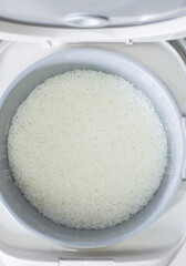 White rice in a bowl for cooking in the kitchen, top view