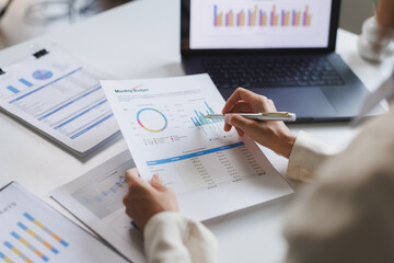 Businesswoman analyzing financial charts and graphs for monthly budget