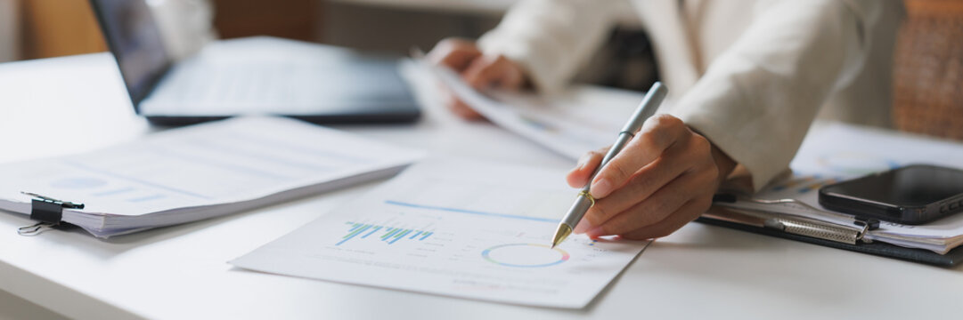 Businesswoman analyzing financial charts and business documents - Powered by Adobe