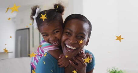 Mother and daughter sharing piggyback ride and laughing joyfully in modern home, with star graphics