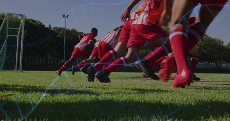 Sprinting seven athletes wearing red kits and cleats across soccer field toward goal, with overlays