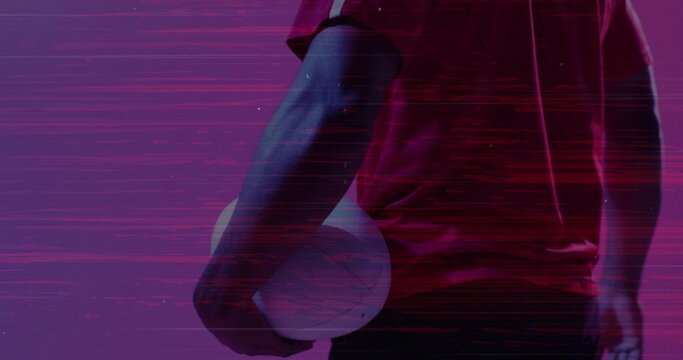 Standing athlete wearing red jersey holding white volleyball in studio glitch backdrop, copy space