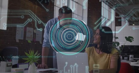 Collaborating male and female coworkers reviewing data on laptop at office desk with HUD overlay