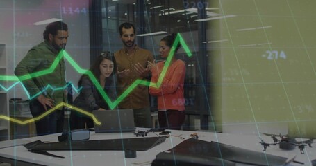 Collaborating five adults examining prototype drones and laptop in tech lab with VR goggles, cables
