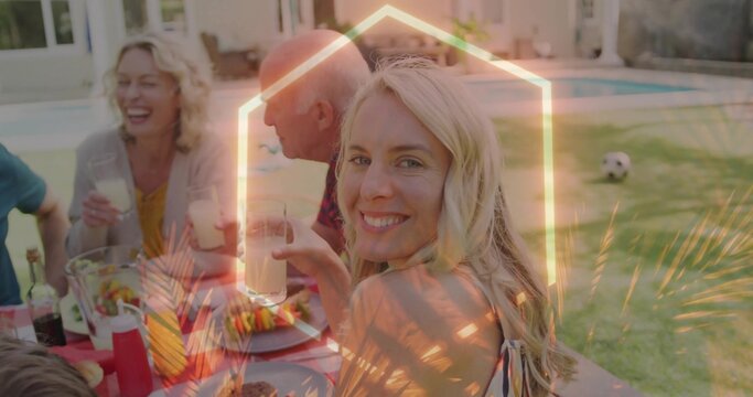 Smiling mid adult woman in summer dress sipping drink at backyard patio table, with salad bowl