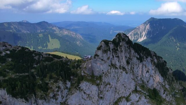 4K Aerial drone video of Tegernseer H&uuml;tte, incredible cabin nested in the mountains between Ro&szlig;stein and Buchstein peaks in German Alps with beautiful nature surrounding Leonhardstein on a sunny day