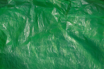 Green plastic textured background with wrinkles and creases. For graphic design, 3D rendering and...