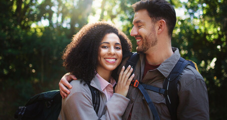 Happy, hikers and couple in nature, portrait or hug on adventure, love and break on holiday or trip. Outdoor, people and bonding on journey, backpacking and smile on vacation, traveller and woods