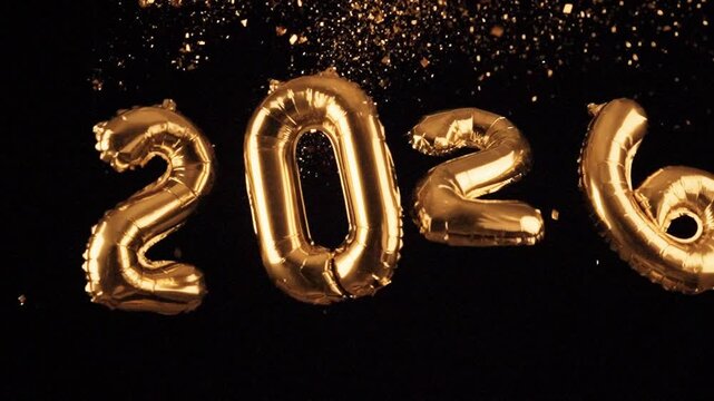 Sparkling golden 2026 new year balloon and vibrant, flying confetti.Happy new year 2026