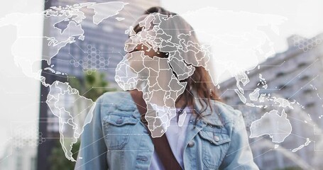 Woman tapping smartwatch in plaza and activating translucent world map overlay, exploring tech data - Powered by Adobe